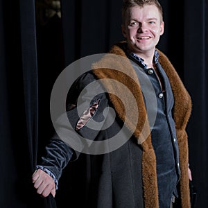 Actor dressed historical costume in interior of old theater.