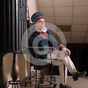 Actor dressed historical costume in interior of old theater.