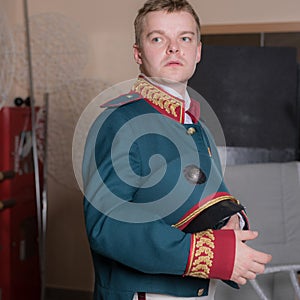 Actor dressed historical costume in interior of old theater.