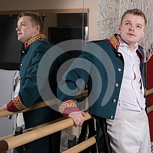 Actor dressed historical costume in interior of old theater.