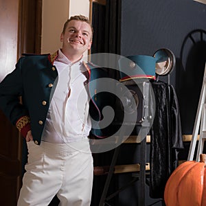 Actor dressed historical costume in interior of old theater.