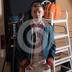 Actor dressed historical costume in interior of old theater.