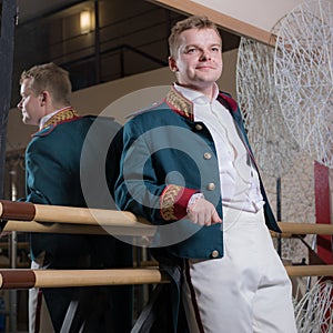 Actor dressed historical costume in interior of old theater.