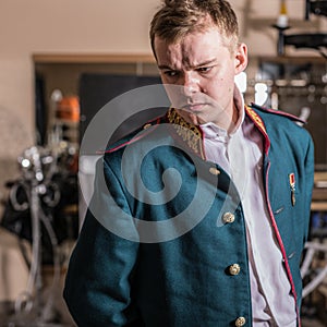 Actor dressed historical costume in interior of old theater.