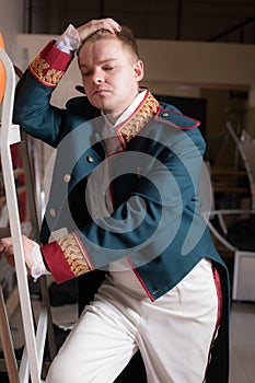 Actor dressed historical costume in interior of old theater.