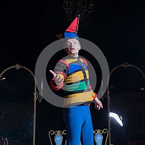 Actor dressed jester`s costume in interior of old theater.