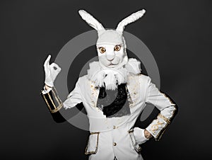 Actor posing in white rabbit suit on black