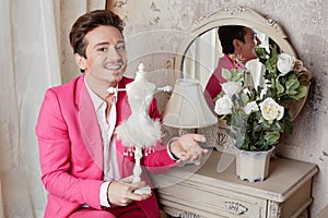 Actor sits holding stylized statuette at table