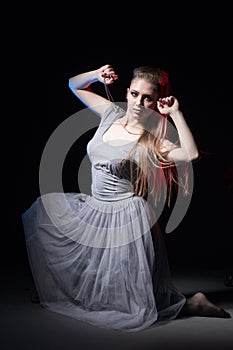 Actress in a grey dress on a dark stage