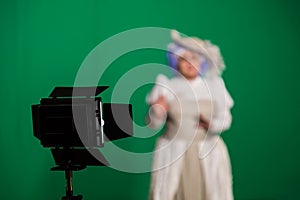 The actress shot on green background. Lighting equipment in the Studio