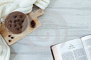 Acts of the apostles open holy bible book with coffee cup on table with copy space, top view