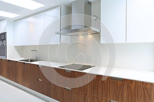 Actual modern kitchen in white and walnut wood