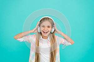 She is actually a big music fan. Happy little child enjoy music playing in headphones. Little girl child listening to