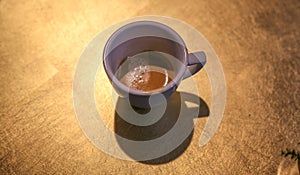 ACup of coffee under a rustic wooden table very beautiful and bright clothing