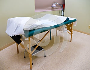 Acupuncture, Massage Table & Heat Lamp In Treatment Room