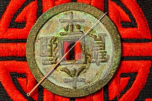 Acupuncture needle on Chinese coin and symbol for immortality