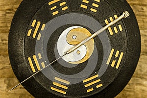 Acupuncture needle on Chinese Taoism symbol photo