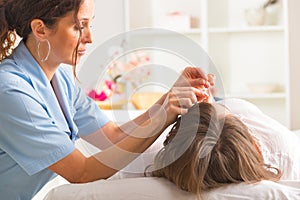 Acupuncture therapist applying acupuncture needle