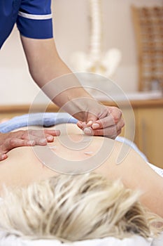 Acupuncturist treating female client