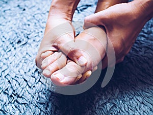 Acute foot pain of thai Asian women, Using hand massage on feet to relieve severe sore feet. Medical health care concept photo
