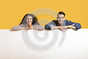 Ad Banner. Smiling Arab Couple Leaning At Blank White Advertisement Board