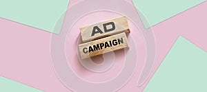 Ad Campaign on Wooden Blocks on pink background. Marketing advertising Concept