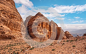 Ad Deir - Monastery - ruins carved in rocky wall at Petra Jordan, mountainous terrain with blue sky background