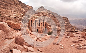 Ad Deir - Monastery - ruins carved in rocky wall at Petra Jordan, mountainous terrain with blue sky background