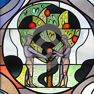 Adam and Eve on stained glass in St. Jodokus Church, Immenstaad, Germany.