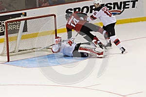 Adam Henrique collides against Cory Schneider of the New Jersey Devils