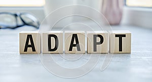 adapt text written on cubes wooden. on the background of a notebook