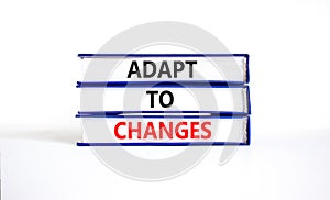 Adapt to changes and support symbol. Concept words Adapt to changes on books. Beautiful white table white background. Business and