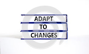 Adapt to changes and support symbol. Concept words Adapt to changes on books. Beautiful white table white background. Business and