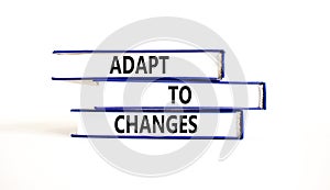 Adapt to changes and support symbol. Concept words Adapt to changes on books. Beautiful white table white background. Business and