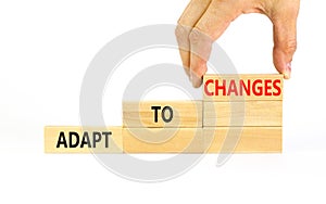 Adapt to changes symbol. Concept words Adapt to changes on wooden blocks. Businessman hand. Beautiful white table white background