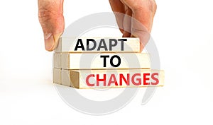 Adapt to changes symbol. Concept words Adapt to changes on wooden blocks. Businessman hand. Beautiful white table white background