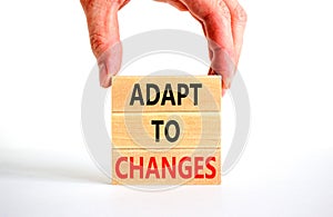 Adapt to changes symbol. Concept words Adapt to changes on wooden blocks. Businessman hand. Beautiful white table white background