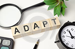 adapt word made with wooden blocks and office supplies