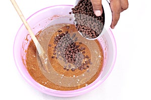 Add the choco chips to the top of the muffin batter - membuat kue muffin
