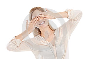 Add some play to your day. Studio shot of a beautiful young woman playfully covering her eyes against a white background