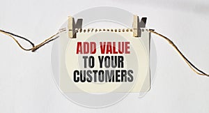 ADD VALUE TO YOUR CUSTOMERS text words inscription on yellow sticker note on white wall or table