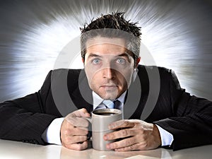 Addict businessman holding cup of coffee anxious and crazy in caffeine addiction photo