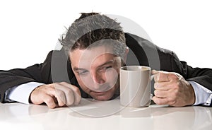 Addict businessman in suit and tie holding cup of coffee as maniac in caffeine addiction