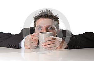 Addict businessman in suit and tie holding cup of coffee as maniac in caffeine addiction photo