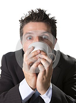 Addict businessman in suit and tie holding cup of coffee as maniac in caffeine addiction