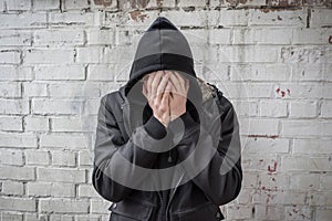 An addict experiencing a crisis of drug addiction after prolonged use of drugs and alcohol. A man covering his face with his hands