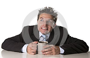 Addicted businessman in suit and tie holding cup of coffee as maniac in caffeine addiction