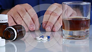 Addicted Person with Hands Shaking Take Medicament from the Table with Alcohol