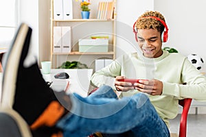 Addicted young teenage man playing video games on mobile phone app at home