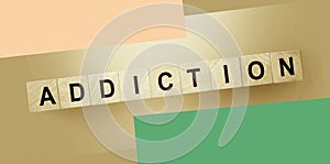 ADDICTION word on wooden cubes on a dark wood background